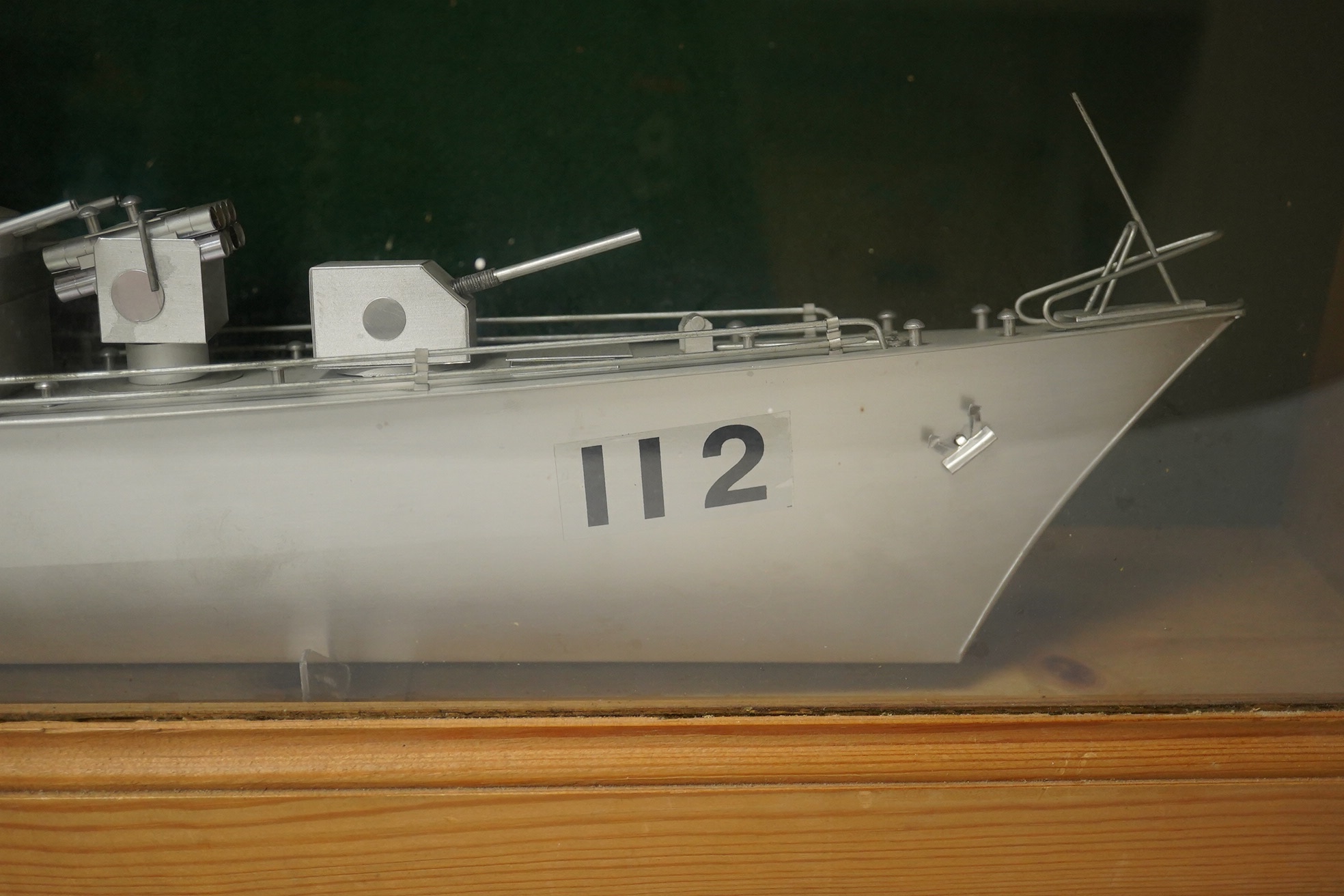 A pine cased aluminium model of a naval frigate, hull 86cm long, display case 96.5 x 18 x 36cm. Condition - good.